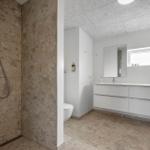 Dusche mit Steinwand, Waschtisch mit Spiegel und Fenster