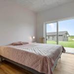Schlafzimmer mit Bett, Schlafcouch und großem Fenster zur Aussicht.