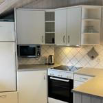 Küche mit Kühlschrank, Mikrowelle und Herd unter Dachschrägen