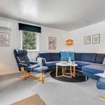 Ein Wohnzimmer mit blauem Sofa, zwei blauen Sesseln und einem runden Tisch.