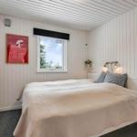 Schlafzimmer mit Bett, Fenster und Wandbildern.