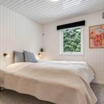 Schlafzimmer mit Bett, Fenster und Wandbildern.
