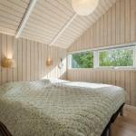Bedroom with wooden walls, bed, and window to the garden.