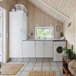 Living area with washing machine, sink, and wood paneling.