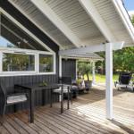 Patio with table, chairs, and lounge chairs under roof