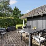 Terrace with table, chairs, grill, and planters. Backyard with hedge and lawn.