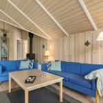 Living room with blue sofas, wooden walls, and fireplace.