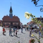 Historic town hall with tower and market on cobblestone street