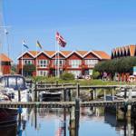 Red houses by the harbor with boats and flags