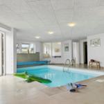 Indirekt beleuchteter Innenpool mit grünem Krokodil-Strandball und Außentür.