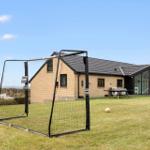 Modernes Haus mit großem Garten, Fußballtor und Spielplatz.