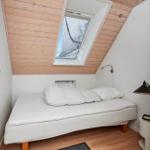 Schlafzimmer mit Dachschrägen, Bett, Fenster und Schrank.