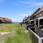 Reihen von Ferienhäusern mit Terrassen und roten Dächern am Strand