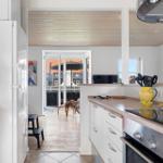 Küche mit Holzboden und Blick auf Terrasse mit Sonnenschirm.