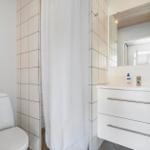 Badezimmer mit Toilette, Dusche und Waschbecken mit Spiegel.