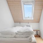 Schlafzimmer mit Dachfenster, Bett und Nachttisch.