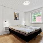 Schlafzimmer mit Bett, Fenster und Wandbild.