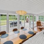 Essbereich mit Tisch und Stühlen. Durchgänge zu Garten mit Grill und Sitzgruppe.