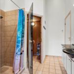 Badezimmer mit Dusche, Waschbecken und Sauna.