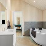 Bathroom with bathtub, sink, and wooden walls