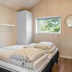 Bedroom with wooden walls, bed, window, and mirror