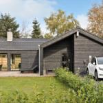 Modern wooden house with terrace, barbecue area, and parking for one car.