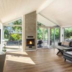 Living room with fireplace, TV, and large window view of garden