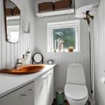 Badezimmer mit Waschbecken, Toilette und Fenster