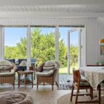 Wohnraum mit Sitzgelegenheiten, Tisch und Blick auf Garten
