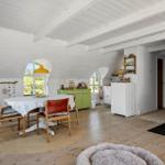 Esszimmer mit Holzboden, Kamin und grüner Schrank
