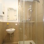 Bad mit Dusche, Waschbecken und Spiegel