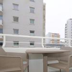 Balkon mit Tisch und zwei Stühlen. Blick auf Wohnhäuser.