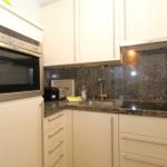 Küche mit Edelstahlherd, Spüle und Granit-Arbeitsfläche.