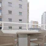 Balkon mit Tisch und zwei Stühlen, Blick auf Hochhäuser