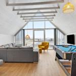 Wohnraum mit Pooltisch, Sofa und großem Fensterblick.