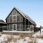 Moderne Villa mit Glasfassade und Terrasse im Schnee.