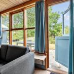 Living room with sofa, wooden wall, and view of garden