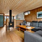 Living room with fireplace, sofa, and kitchen area