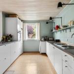 Kitchen with white cabinets, green walls, and dark wood countertops.