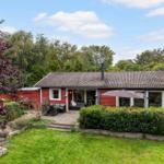 Red house with terrace, garden, and view into the woods.