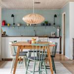 Kitchen with dining area, wooden table, chairs, and pendant light.