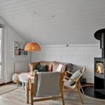 Wohnzimmer mit Sofa, Kamin und Esstisch. Durchgang zur Terrasse.