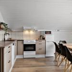 Küche mit Essbereich, Holzfußboden und weißer Decke.
