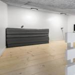 Raum mit grauem Sofa, Fernseher und Holzboden