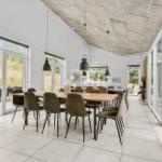 Großer Essbereich mit Holztisch, Stühlen und Glasfronten zur Terrasse.