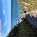 View of the sea with a wooden staircase and a person on the beach.