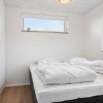 Schlafzimmer mit weißem Bett, Fenstern und Wandbildern.