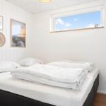 Schlafzimmer mit Bett, Fenster und Wanddekoration.