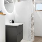Badezimmer mit Waschbecken, Spiegel und Duschvorhang