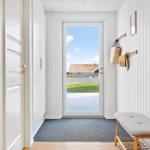 Eingangsbereich mit Tür zum Garten, Wandgarderobe und Sitzbank.